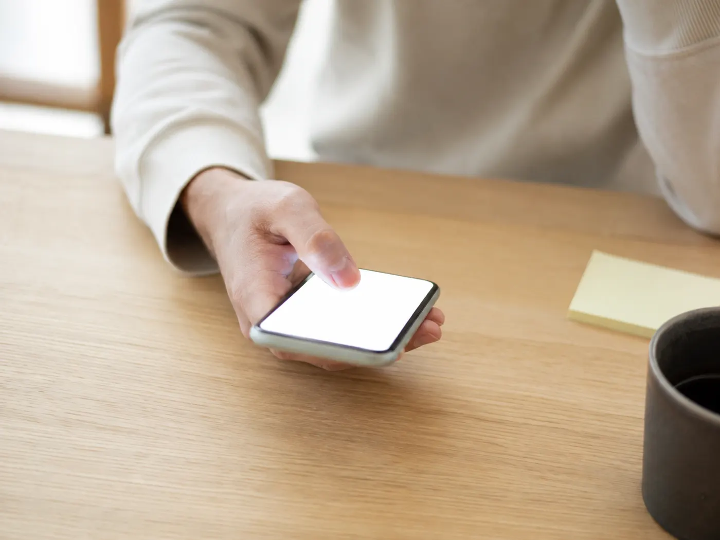 スマートフォンで連絡のやりとりをする手元